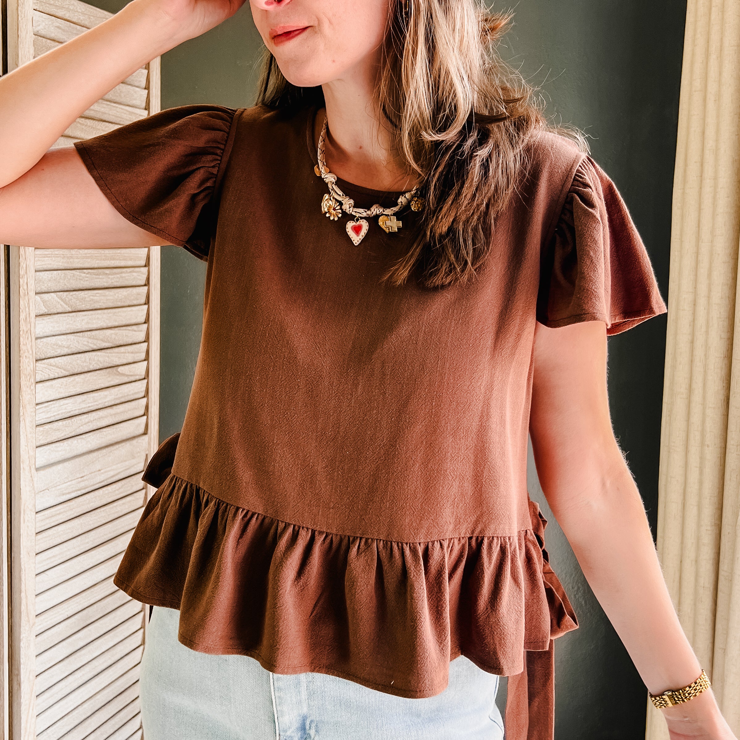 A scoop neck, flutter sleeve top with side ties with flowy ruffle bottom for women brown