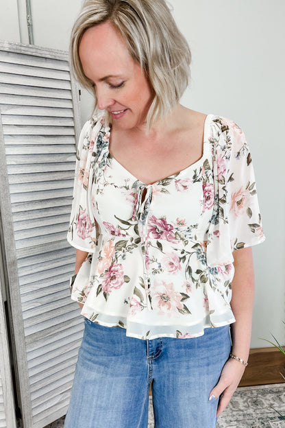 Women's floral top with flutter sleeves and tie front.
