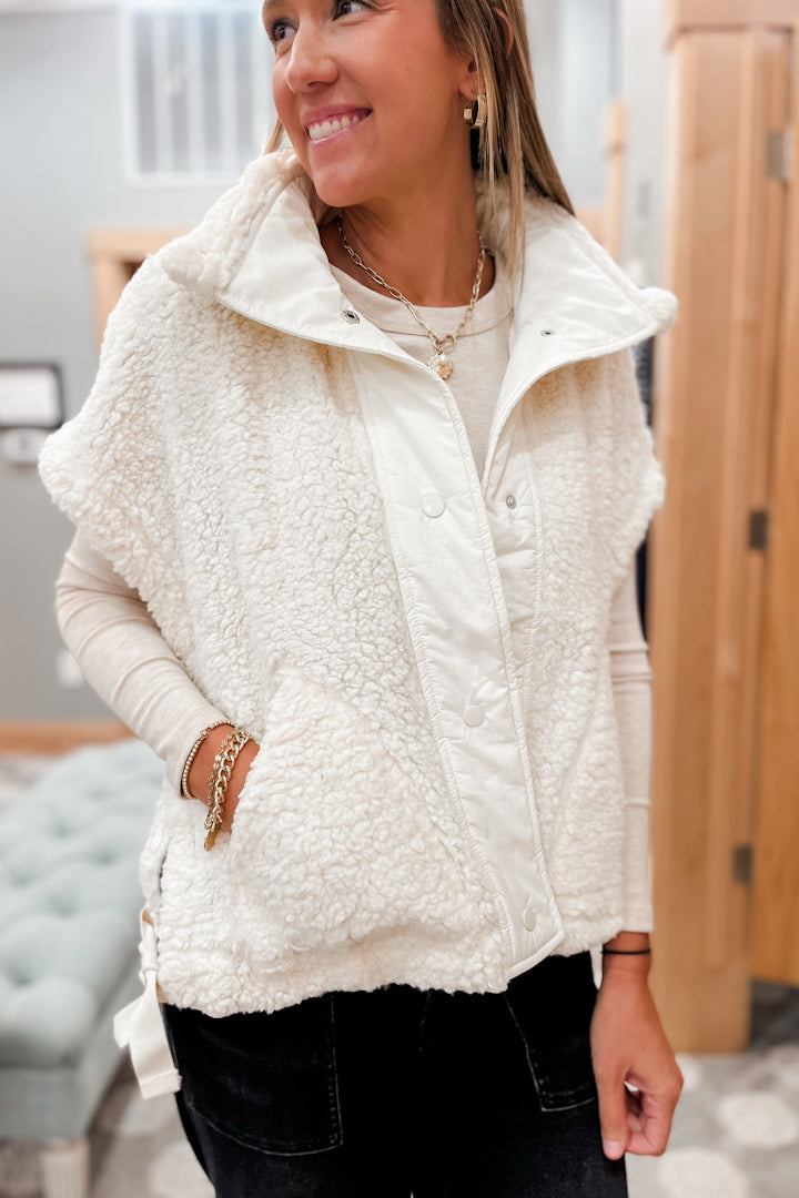 Woman wearing a white fleece vest indoors