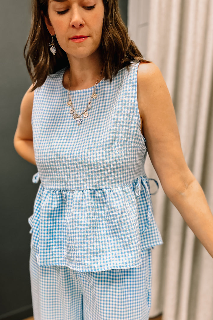 Sleeveless gingham peplum top with side tie detail