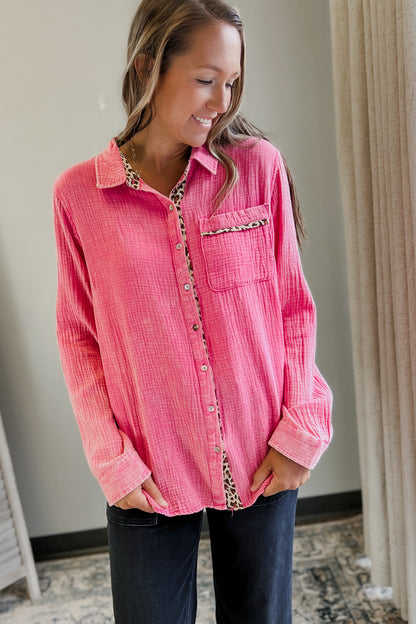 Woman wearing a pink corduroy shirt with a patterned collar and buttons, standing indoors.