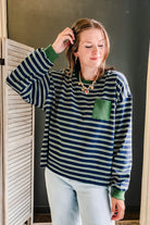 A crew neck long sleeve green/navy stripe top with a front pocket detail for women.
