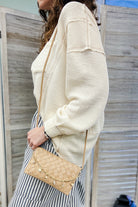 A woven slim envelope with a playful metal sea-inspired charm chain beige