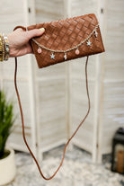 A woven slim envelope with a playful metal sea-inspired charm chain brown