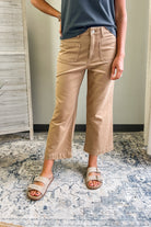 Person wearing beige pants and sandals on a patterned rug